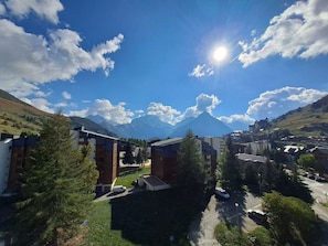 A residential area with modern buildings, a clear sky, and a mountain in the background.