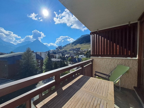 A balcony with a view of a town and mountains.