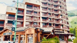 A multi-story hotel with balconies, a wooden facade, and a sign for 'Magic Mountain'.