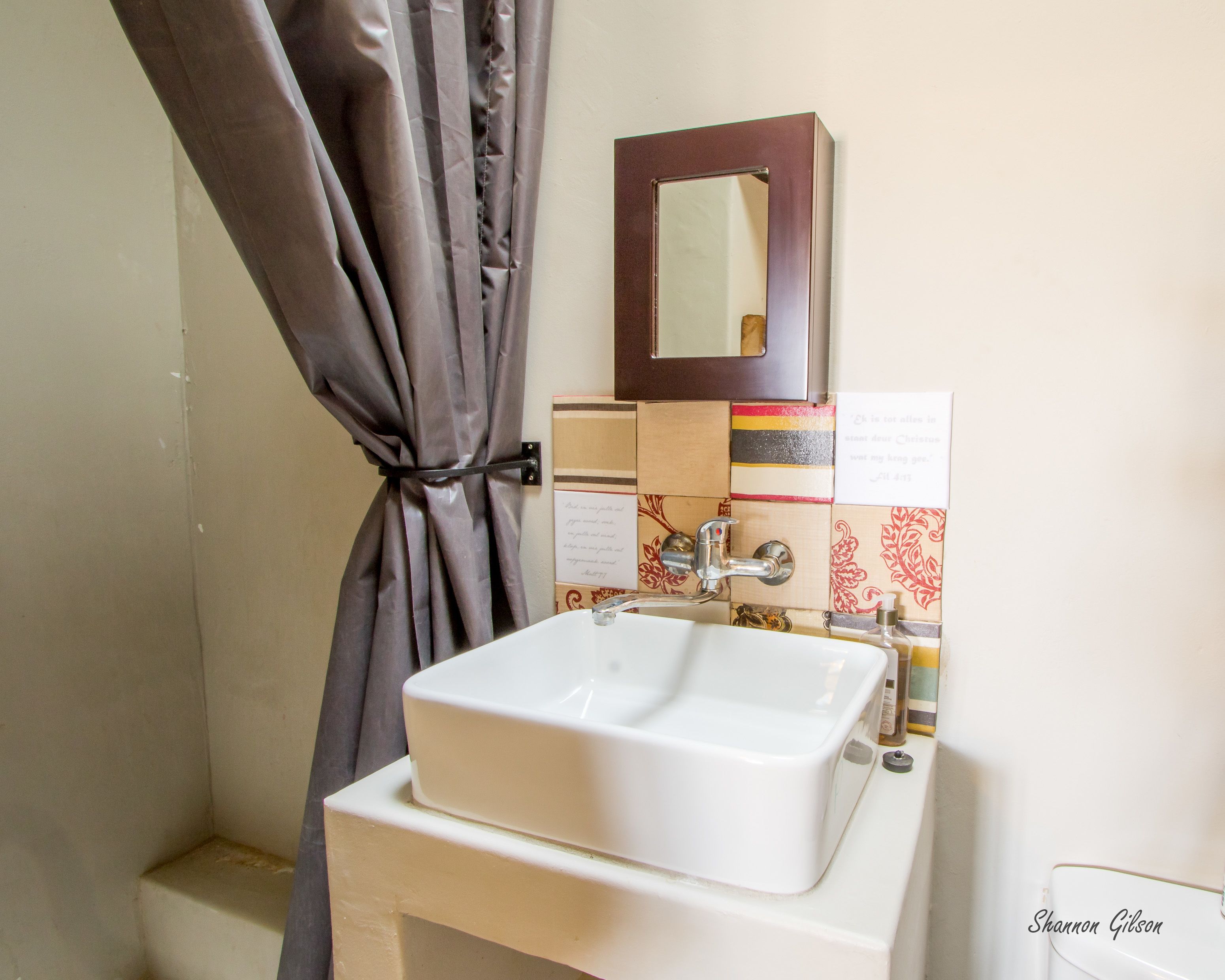 A bathroom with a white sink, a mirror, and a shower curtain.