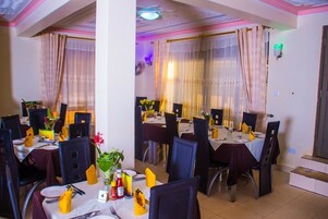 Un comedor con mesas dispuestas para varios comensales, que cuenta con una columna central, sillas y el número de mesa '4'.