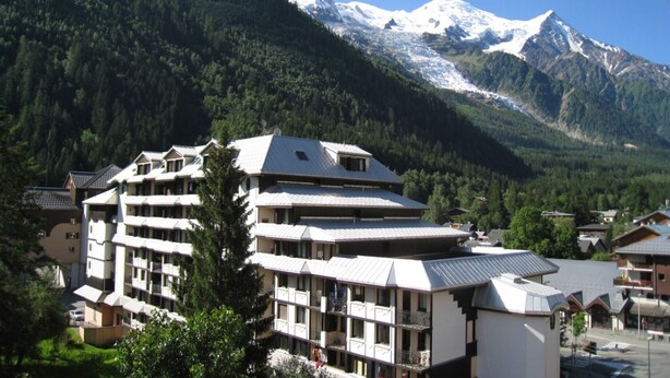 Un hotel a più piani dal design architettonico moderno, con balconi e un cortile centrale.
