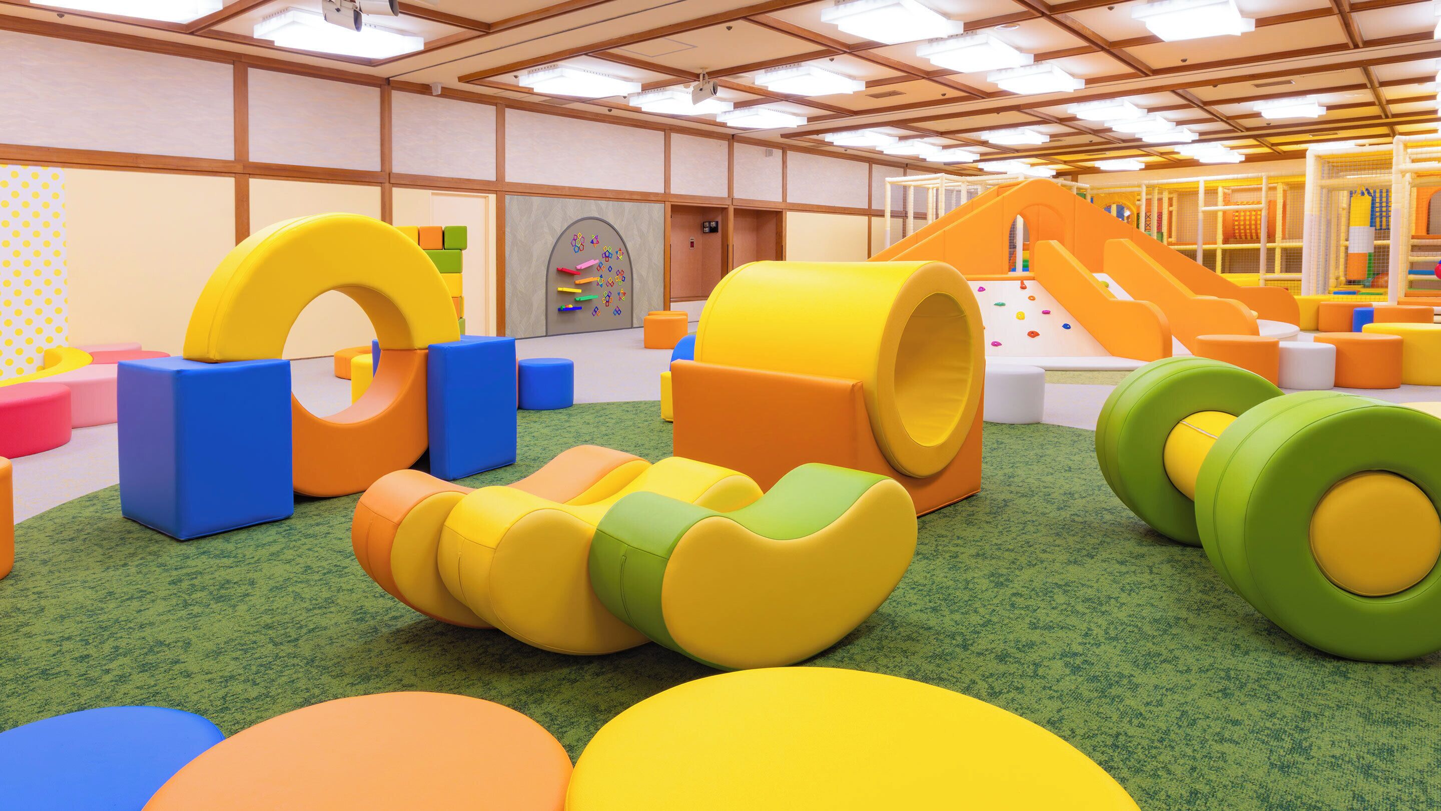 A play area with colorful soft play structures and a slide.