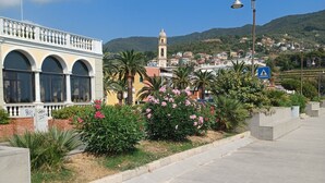 A paved walkway with a building featuring arched windows and a bell tower in the background. - Studio apartment 10 minutes from the 5 Terre (Moneglia)