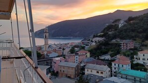 A coastal town with a prominent clock tower, buildings with varied architecture, and a view of the sea and mountains. - Studio apartment 10 minutes from the 5 Terre (Moneglia)