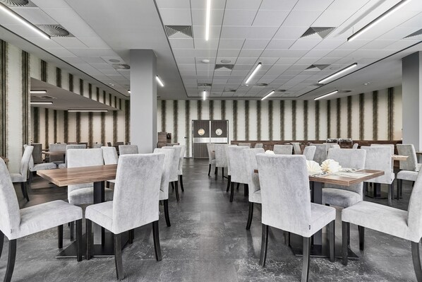 A modern conference room with grey upholstered chairs, wooden tables, and a patterned wall. - DB Hotel Wrocław (Wroclaw)
