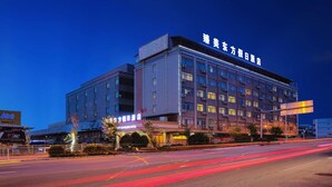 A multi-story hotel with illuminated signage and a modern facade. - Oriental Beauty Hotel (Guangzhou)