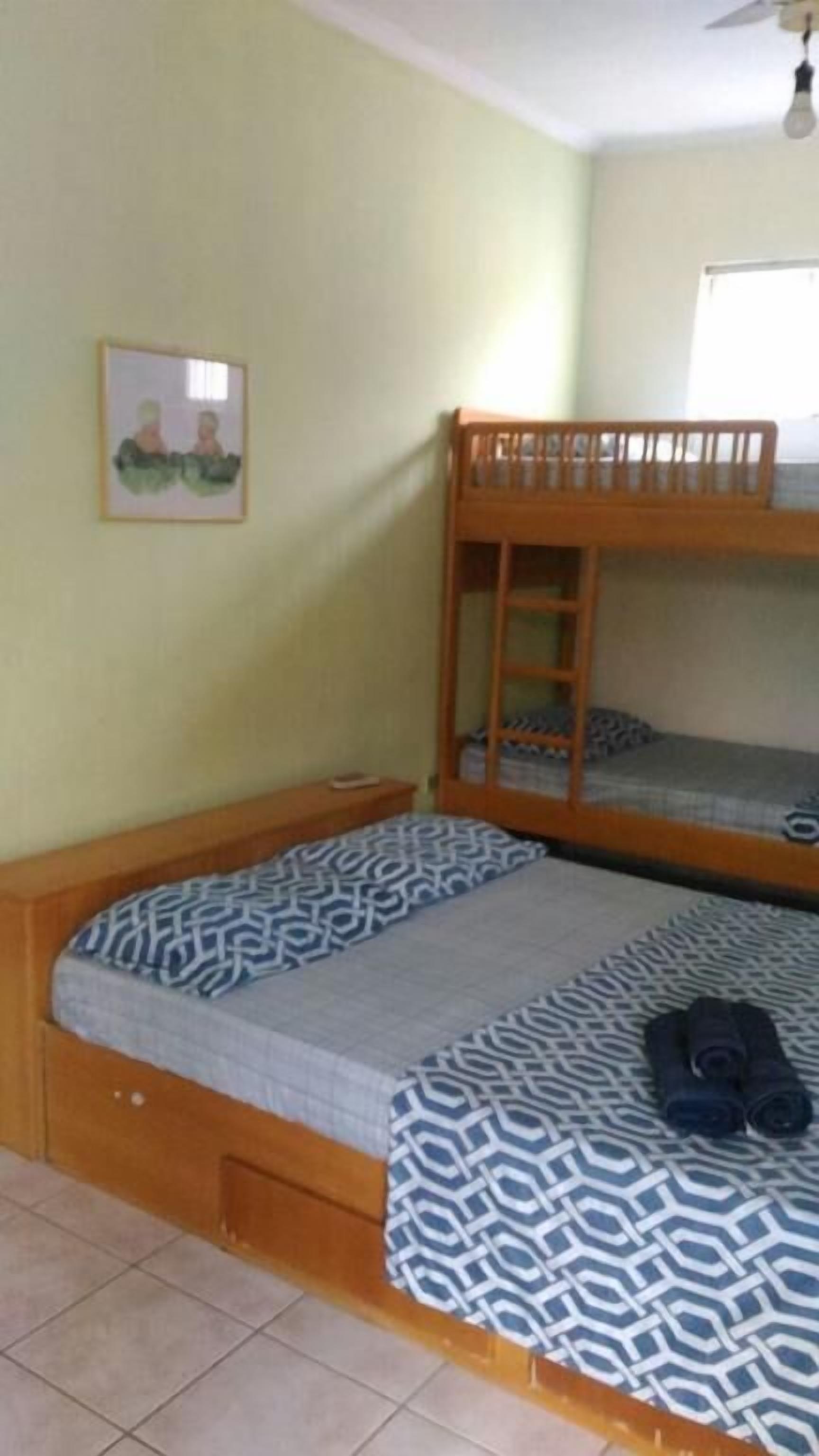 Habitación con literas, una mesita de noche pequeña y un cuadro en la pared.