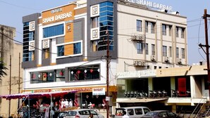 A hotel named "SHAHI DARBAR" with a modern facade, multiple floors, and a visible restaurant and banquet hall. - Hotel Shahi Darbar (Navsari)