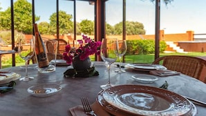A table set for dining with wine glasses, plates, and a bottle of wine. - La Casa del Torero (Vejer de la Frontera)