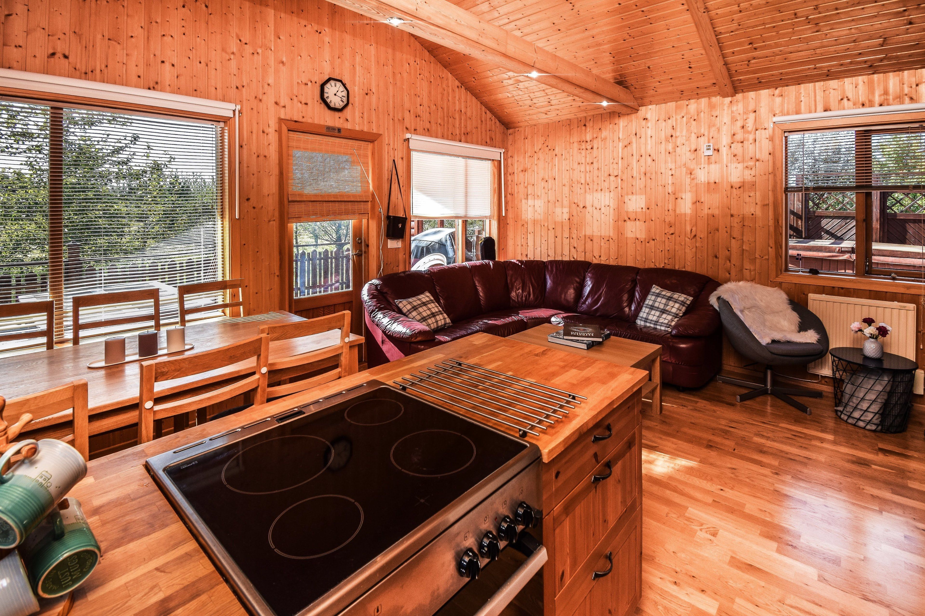 L'intérieur d'une cabane en bois comprend une cuisine, un coin repas et un espace salon.