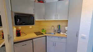 A compact kitchen with a microwave, sink, and dishwasher. - Studio at the slopes of Les Deux Alpes (Les Deux Alpes)