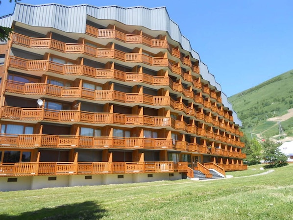 Un hôtel à plusieurs étages, doté de balcons et d’un escalier menant à l’entrée.