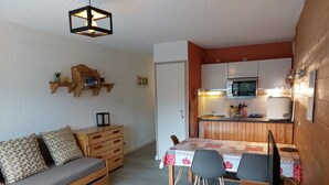 A compact living space with a sofa, a dining table, and a kitchenette. - Studio 4 pers, slopeside, Les Deux Alpes (Les Deux Alpes)