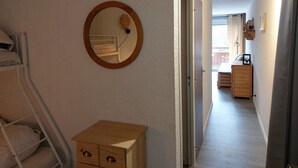 A narrow hallway with a bunk bed, a wooden dresser, and a round mirror on the wall. - Studio 4 pers, slopeside, Les Deux Alpes (Les Deux Alpes)