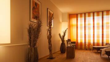 Relax in this inviting living room with a sofa, coffee table, and two vases with dried plants.