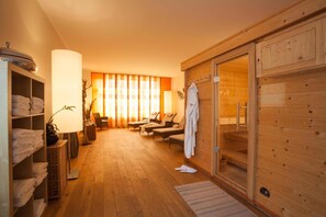 A sauna room with wooden walls, a bench, and a towel rack. - Hotel Barnimer Hof (Wandlitz)