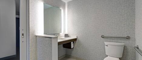 Ein modernes Badezimmer mit Toilette, Waschbecken und Spiegel.