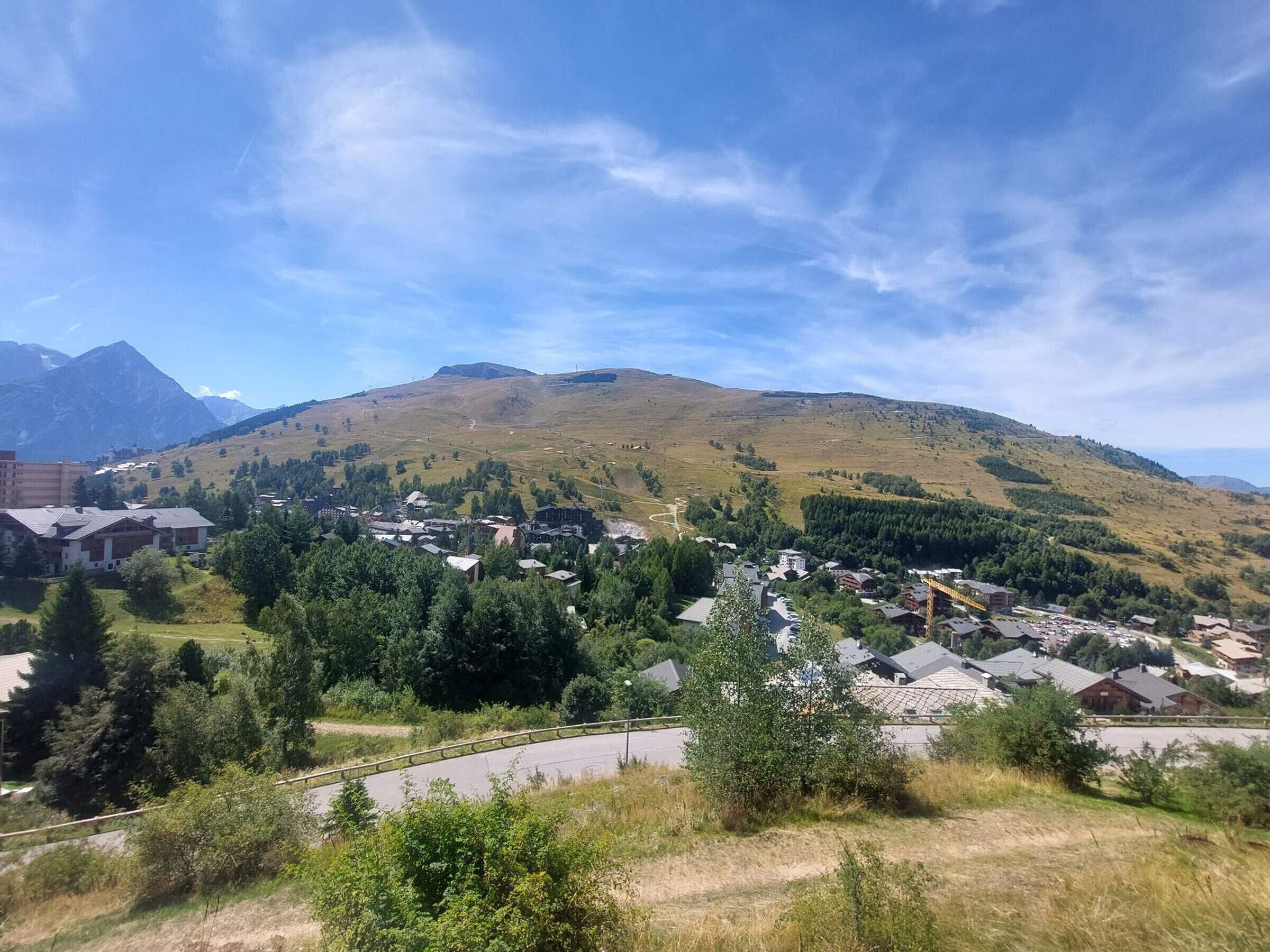 Un área residencial con casas, una carretera y una montaña al fondo.