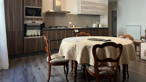 Una cocina moderna con electrodomésticos integrados, una mesa de comedor con sillas y vistas al área de estar contigua.