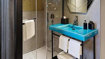 Une salle de bain moderne avec une douche à parois de verre, un lavabo bleu et un grand miroir.