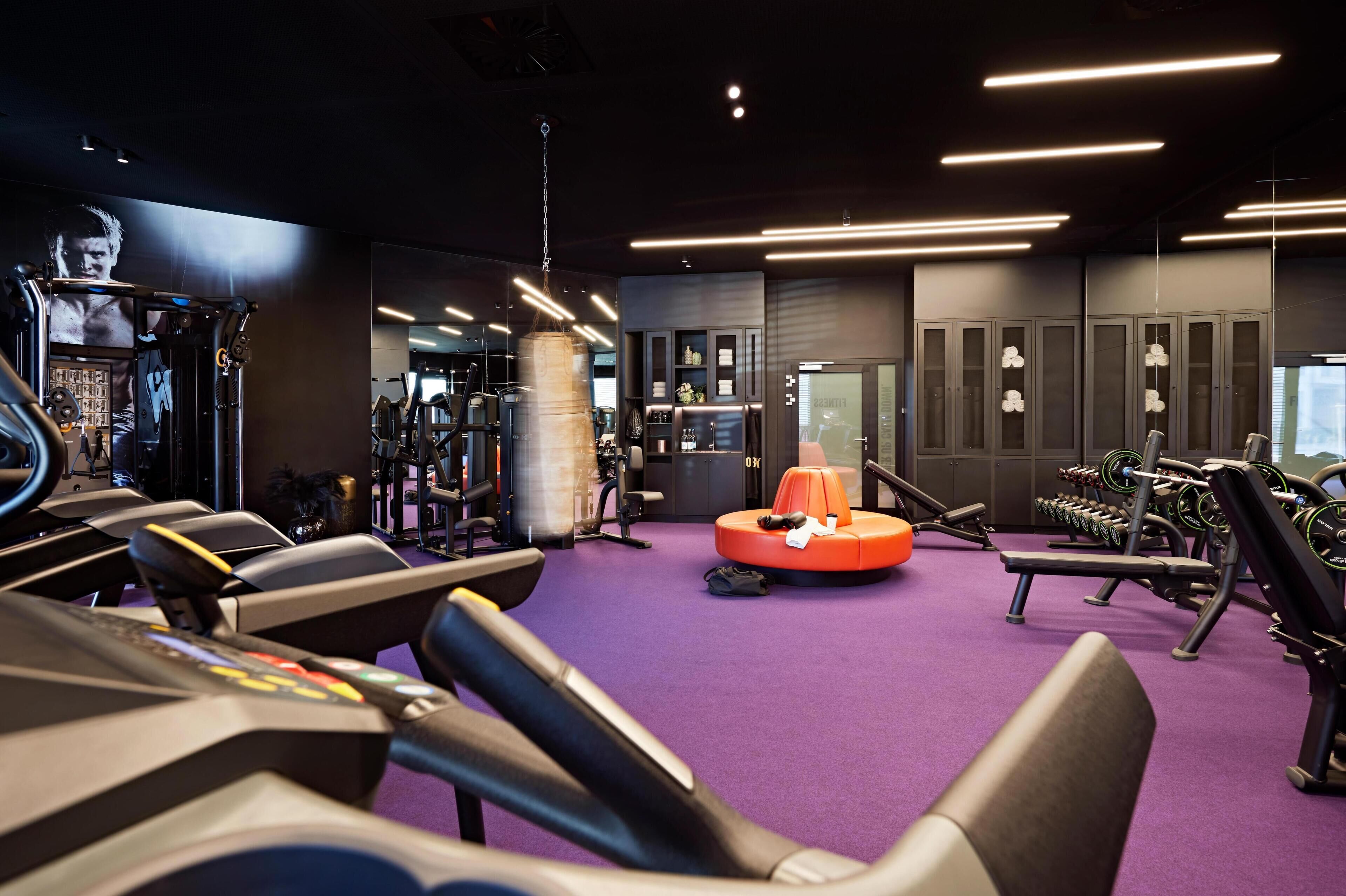 A gym with treadmills, weight machines, and a punching bag.