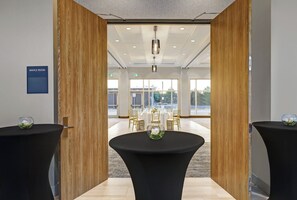 Een vergaderruimte met uitzicht op een buitenruimte, met tafels en stoelen.