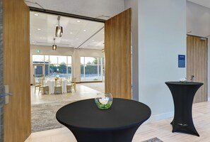 Een modern interieur met een ronde tafel, een glazen vaas en een bordje met de tekst 'eikenkamer'.