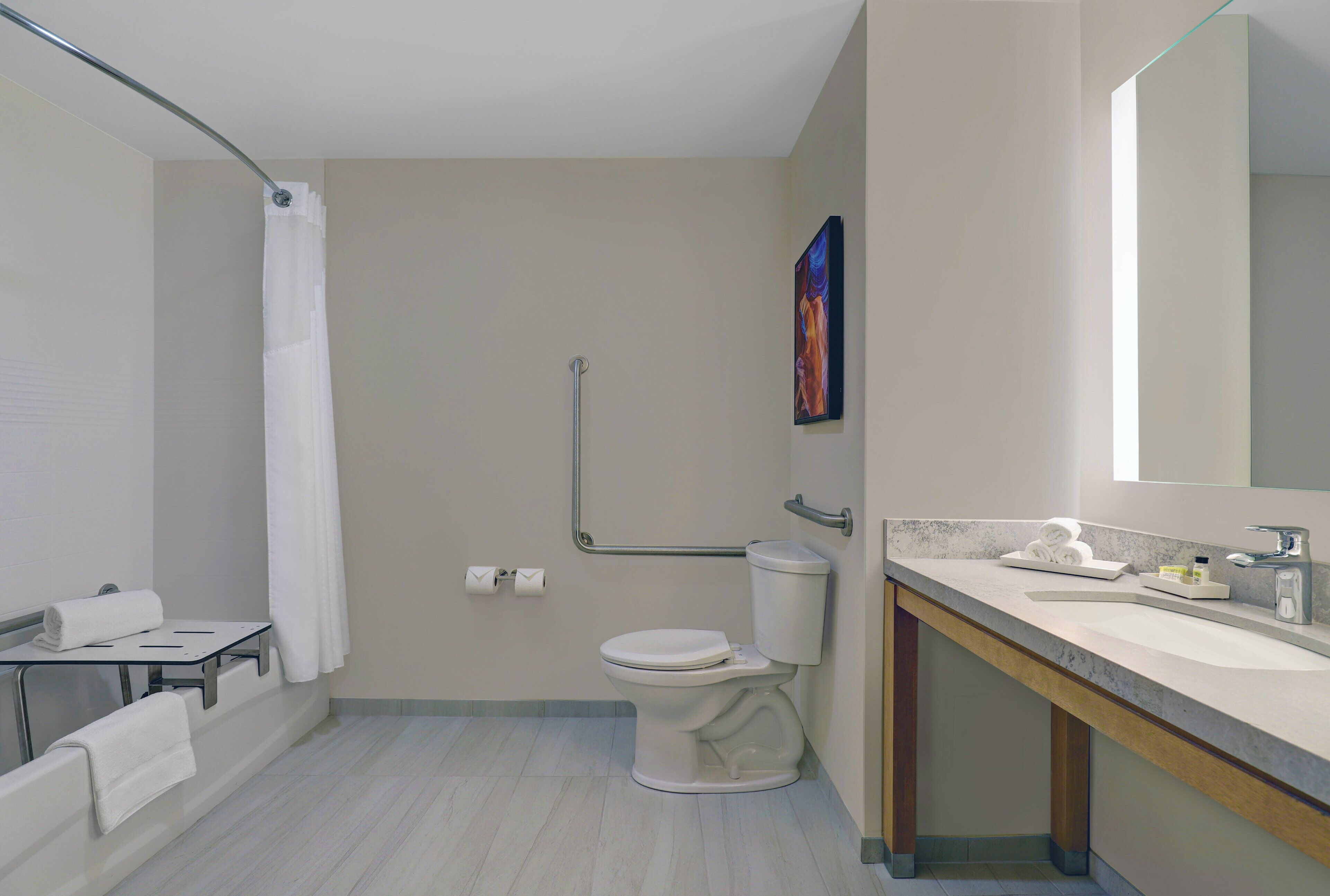 A modern bathroom with a toilet, sink, and shower area.