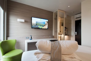 Relax in a stylish room with a flat-screen TV, plush chair, and a comfortable bed.