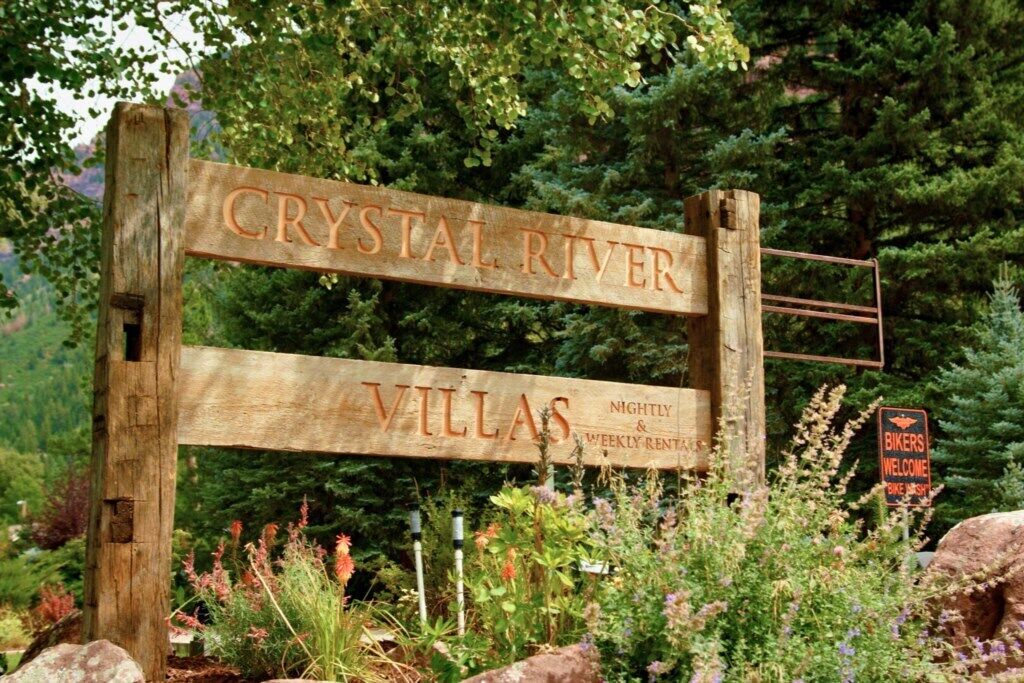 A wooden sign for Crystal River Villas advertising nightly and weekly rentals.