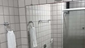Un baño con encimera de granito, un lavabo, un espejo y un perchero para toallas.