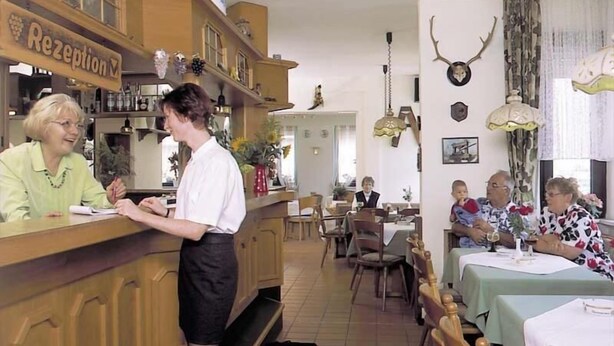 A restaurant with a reception area, wooden furniture, and a dining area with tables and chairs. - Hotel Ockenheim (Ockenheim)