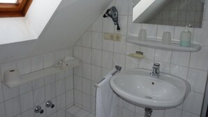 A small bathroom with a skylight, a sink, a mirror, and a towel rack. - Hotel Ockenheim (Ockenheim)