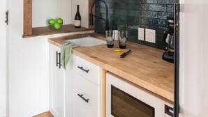 A kitchen with white cabinets, a wooden countertop, a built-in oven, and a black backsplash. - Outpost: Pitchfork 434 - 1 bedroom near Snow King! (Jackson)