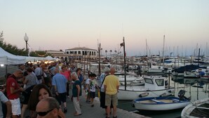 Un puerto deportivo con barcos amarrados y gente caminando.