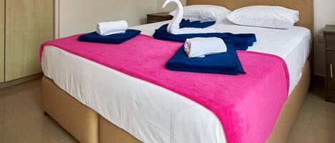 Ein Hotelzimmer mit einem Bett, Kissen und einem schwanenförmigen Handtuch.