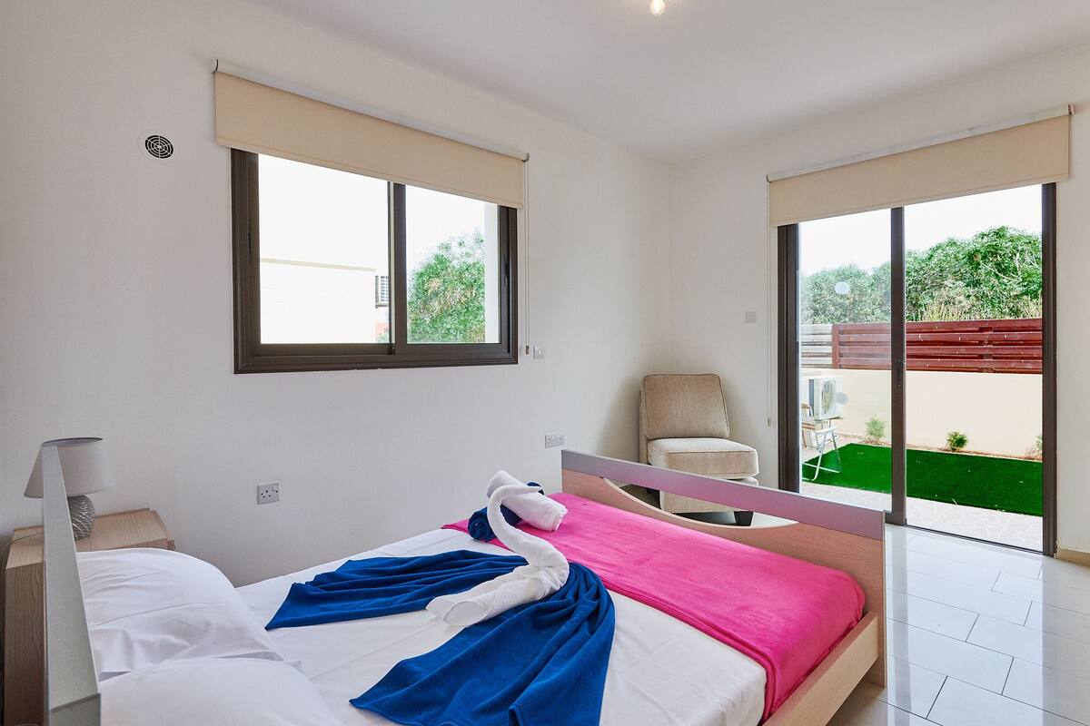 Une chambre à coucher avec un lit, une chaise, une fenêtre et une vue sur l’extérieur.