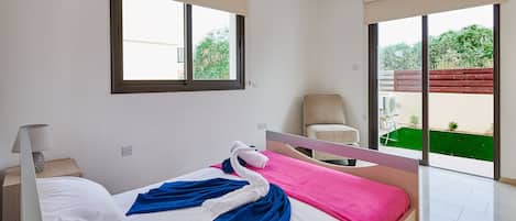 Une chambre à coucher avec un lit, une chaise, une fenêtre et une vue sur l’extérieur.