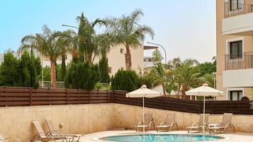 Piscine extérieure, parasols de plage, chaises longues
