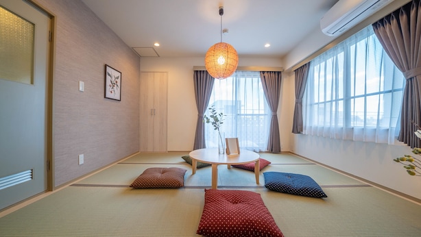 A traditional Japanese-style room with tatami flooring, a low table with cushions, and a hanging light fixture. - Ateliertokyo 5F (Tokyo)
