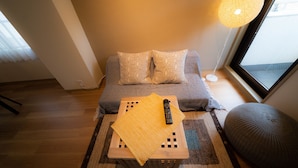 A cozy room with a sofa, a small table with a remote control, and a large window. - Ateliertokyo 5F (Tokyo)