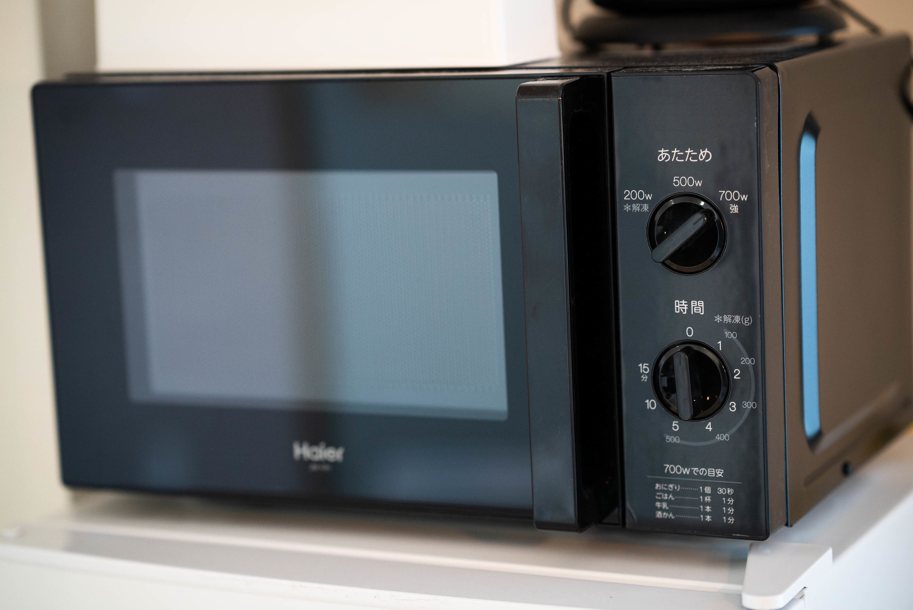 Um forno de micro-ondas preto com visor digital e botões de controle.