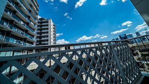 A modern building with multiple balconies and a clear blue sky with clouds. - Ateliertokyo 5F (Tokyo)
