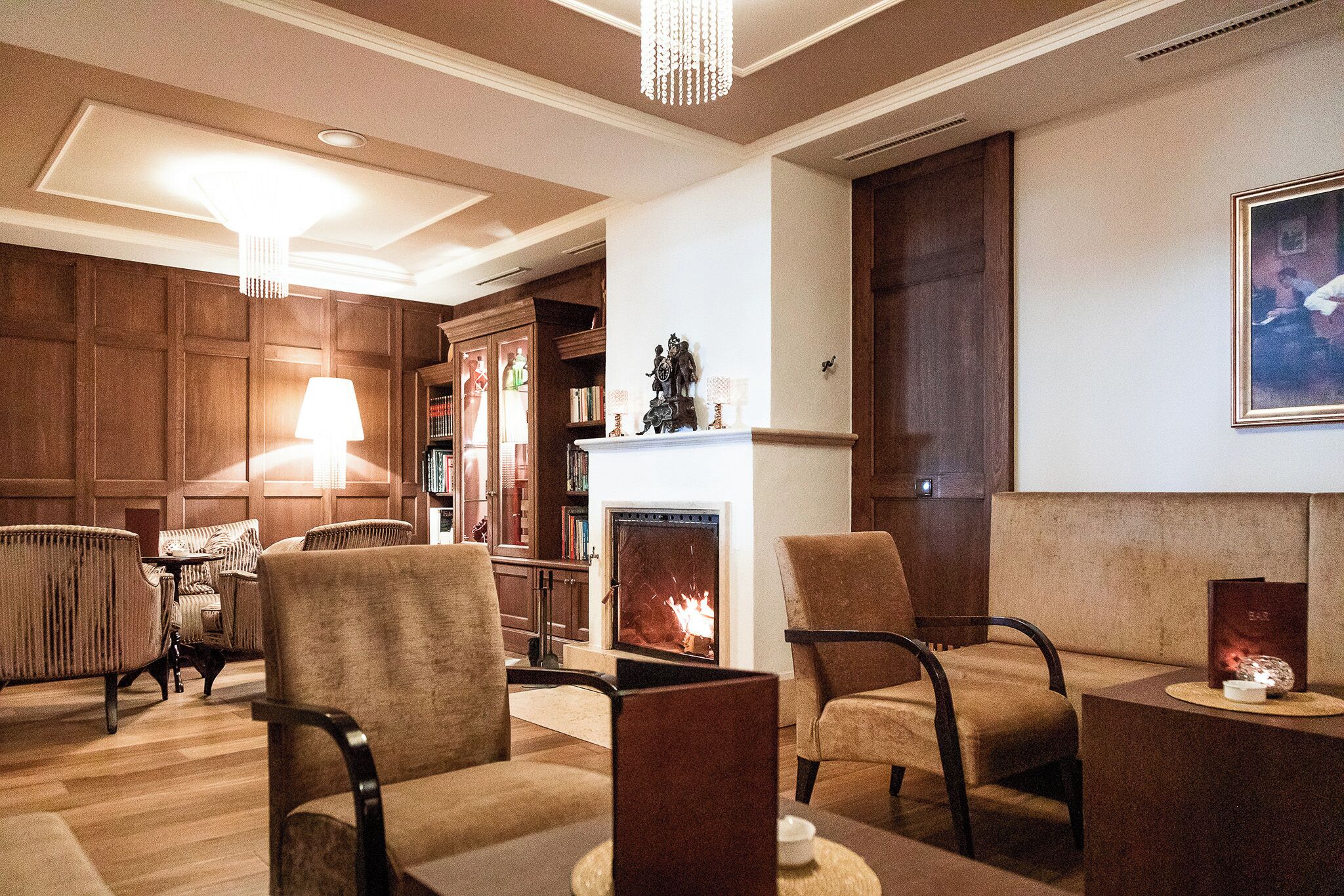 Una sala de estar acogedora con chimenea, asientos cómodos y una estantería.