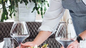 A dining table with a white tablecloth, a plate of food, and wine glasses. - Hotel Klausnerhof (Tux)