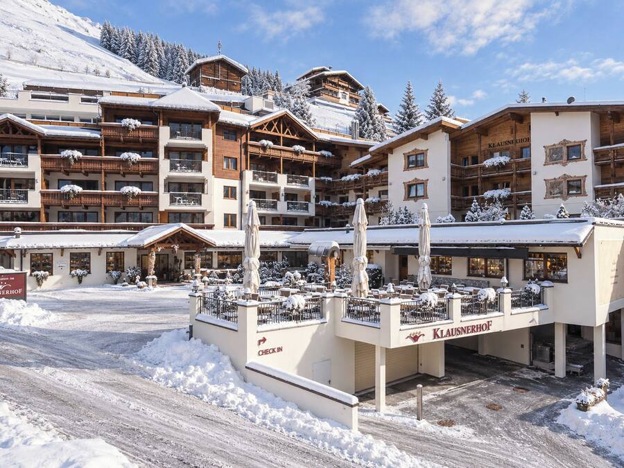 Un hotel cubierto de nieve con varios balcones y una zona de recepción.