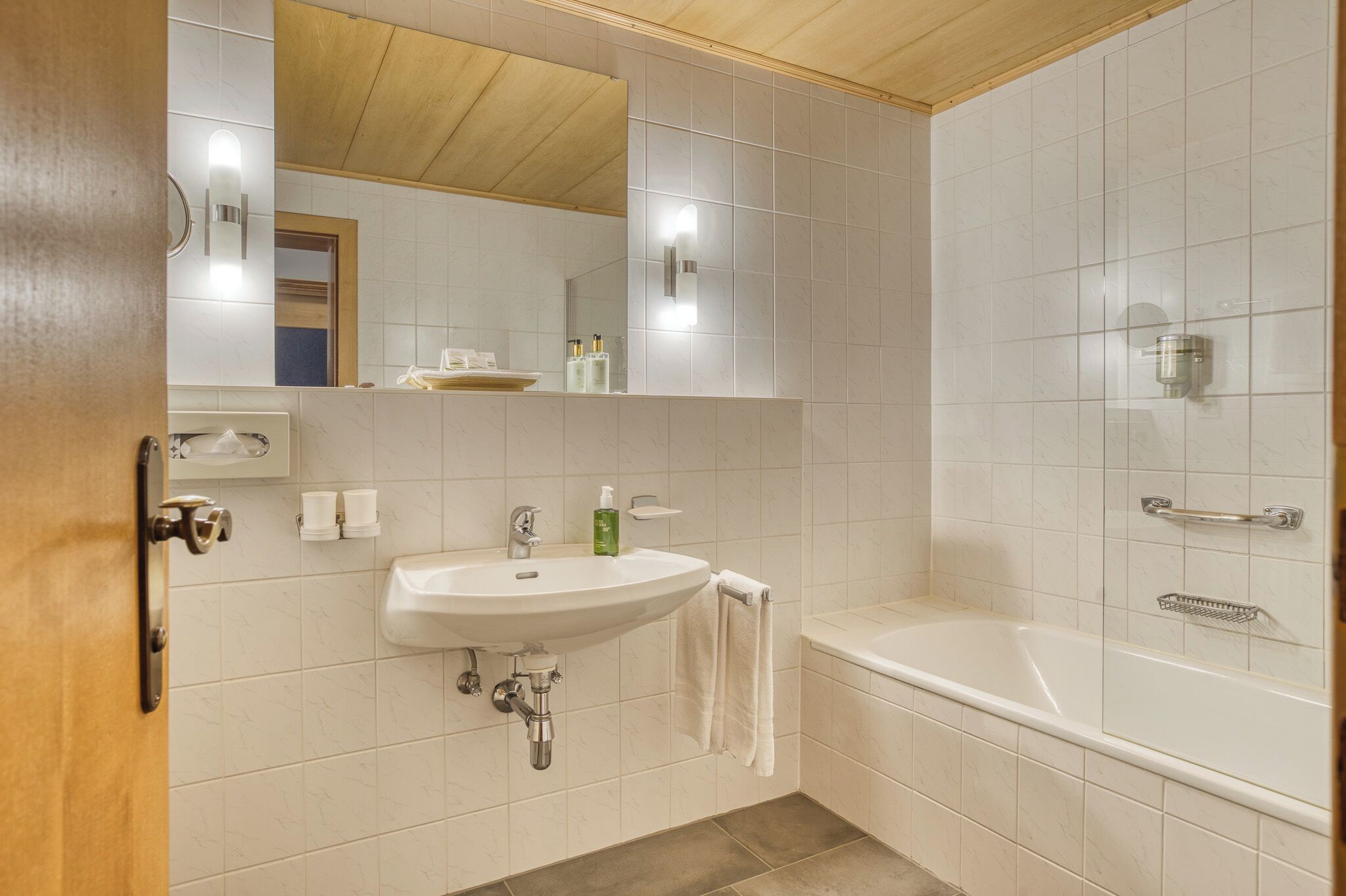 Une salle de bain avec un lavabo, un miroir et une baignoire.