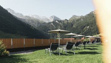 Une terrasse avec des places assises extérieures et une vue sur les montagnes.