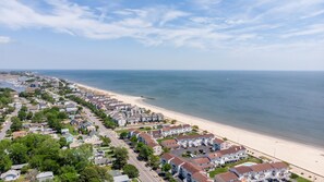 A coastal residential area with houses along the beach, a clear sky, and a calm sea. - Three blocks from the beach (Hampton)